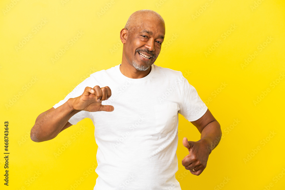 Cuban Senior isolated on yellow background proud and self-satisfied Cuban Senior isolated on yellow background proud and self-satisfied