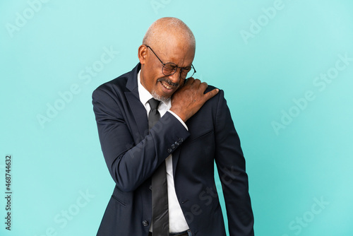 Business senior man isolated on blue background suffering from pain in shoulder for having made an effort