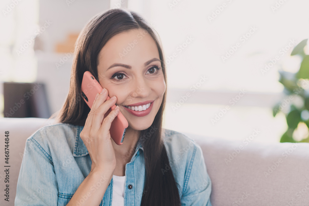 Portrait of attractive cheerful long-haired woman calling friend using roaming contact at light home indoors Portrait of attractive cheerful long-haired woman calling friend using roaming contact at light home indoors