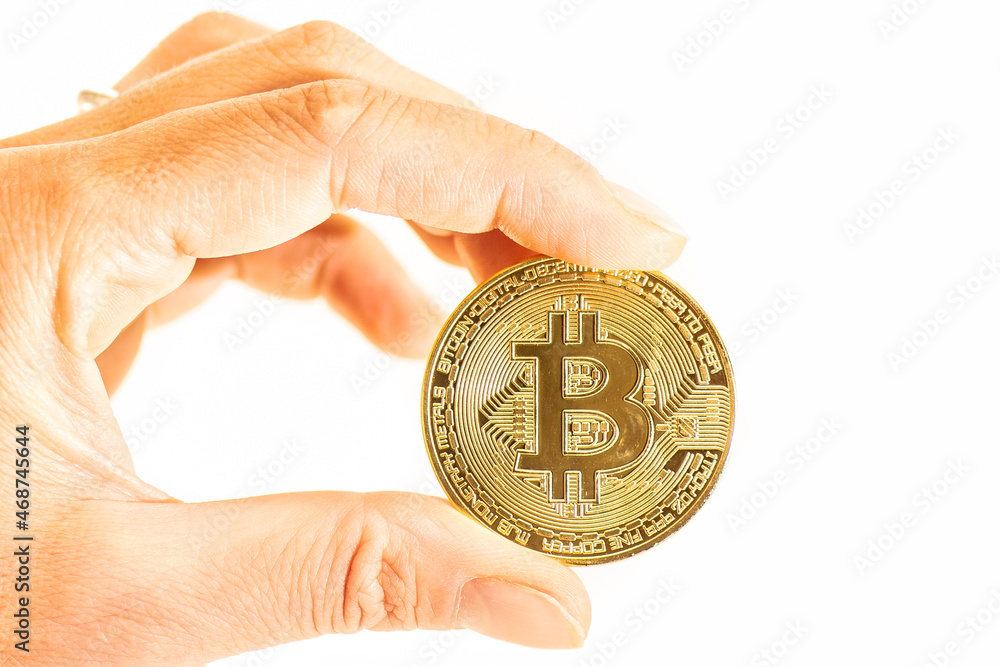 Crypto currency Bit Coin held between fingers_2 Crypto currency Bit Coin held between fingers_2