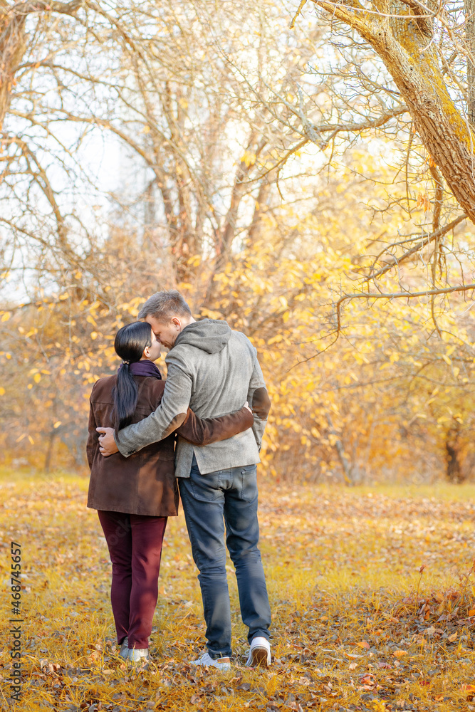 Autumn Caucasian Couple Standing Face-to-Face in a Park Full of Sun. Casual Style in Autumn Colors. Full-length. Fall Park Background Autumn Caucasian Couple Standing Face-to-Face in a Park Full of Sun. Casual Style in Autumn Colors. Full-length. Fall Park Background