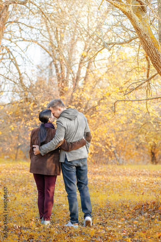 Autumn Caucasian Couple Standing Face-to-Face in a Park Full of Sun. Casual Style in Autumn Colors. Full-length. Fall Park Background © Svyatoslav Lypynskyy