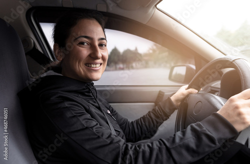 Young woman driving car on the road. Driver licence and driving safety concept.