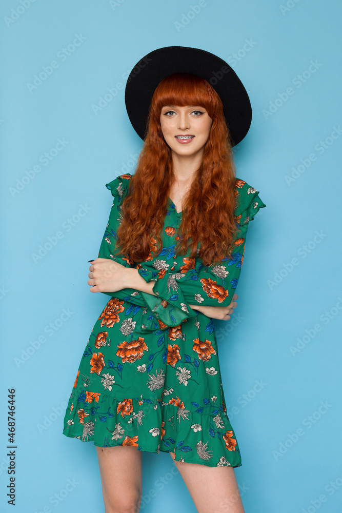 Young red haired woman in green summer dress and black hat. Young red haired woman in green summer dress and black hat.
