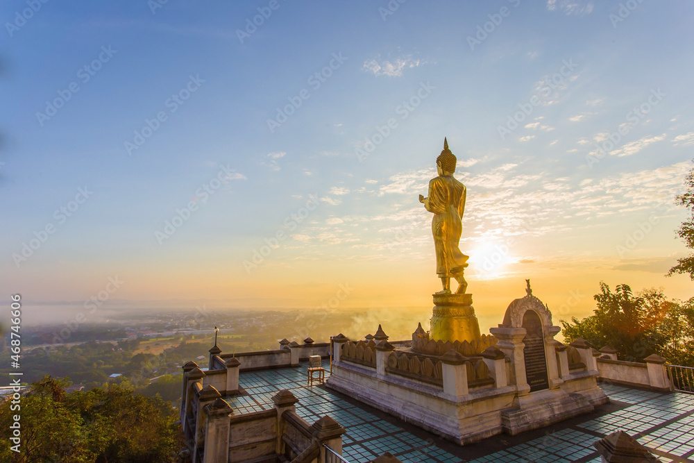 Golden buddha statue inside Phra That Khao Noi temple the temple is located on the hillin the morning with sunshine and bright sky, it is a major tourist attraction of Nan, Thailand.