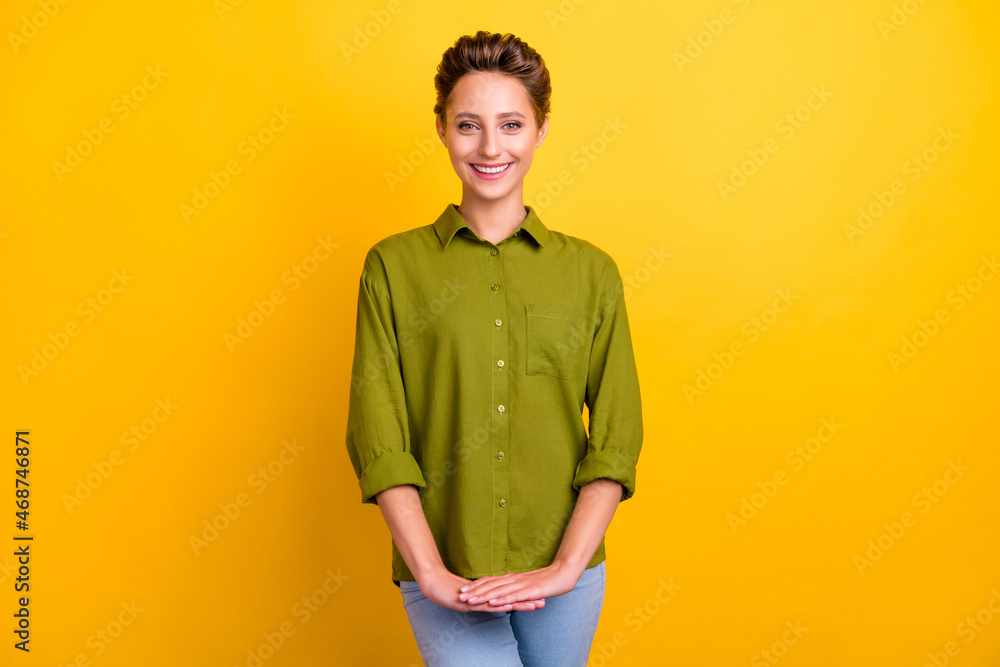 Photo of charming positive lady hold hands beaming smile wear green shirt isolated yellow color background Photo of charming positive lady hold hands beaming smile wear green shirt isolated yellow color background