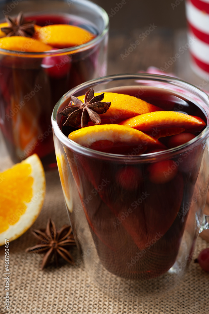 Glass of hot mulled wine with spices on wooden background Glass of hot mulled wine with spices on wooden background