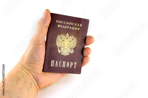 Russian document. The hand holds the Passport. Translation Russian Federation Passport. Radiance emanates from the coat of arms