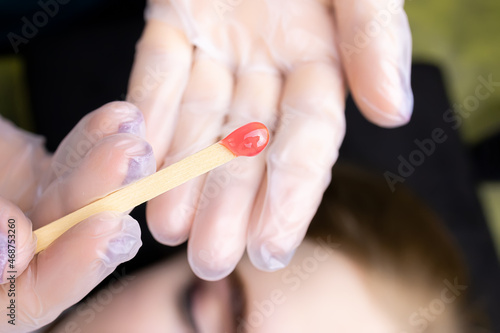there is wax on a wooden stick to remove excess hairs from the eyebrows