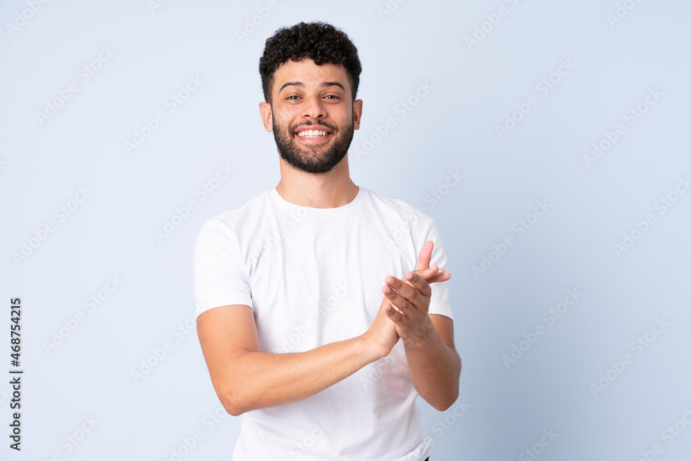Young Moroccan man isolated on blue background applauding Young Moroccan man isolated on blue background applauding