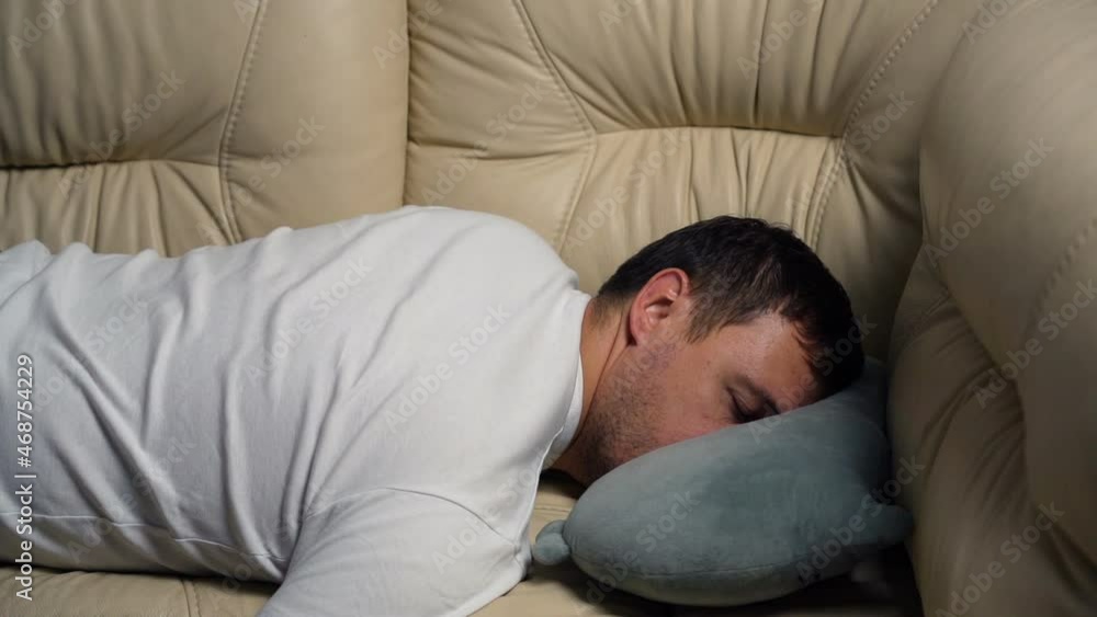 Tired exhausted millennial man falling down on sofa at home after hard working day. Bored male falls on couch pillow, burnout concept. Tired exhausted millennial man falling down on sofa at home after hard working day. Bored male falls on couch pillow, burnout concept.