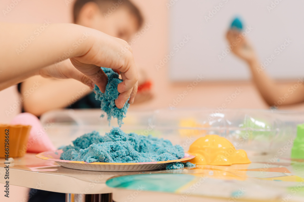 kinetic sand. children's hands play with multi-colored polymer sand. kinetic sand. children's hands play with multi-colored polymer sand.