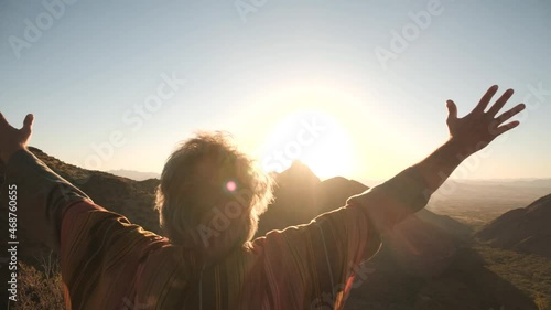 A Bible prophet or holy man raising his arms in praise at sunset