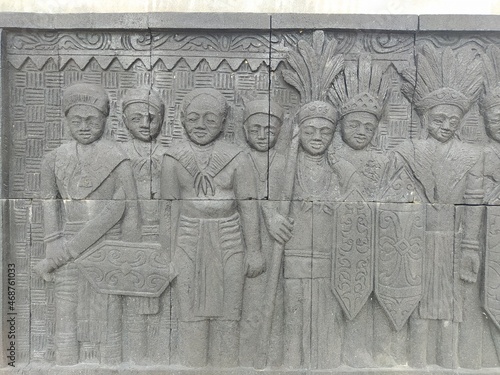 Reliefs of the life of the indigenous people of Kalimantan marching carrying traditional weapons on the walls of Central Park, North Penajam Paser Regency photo