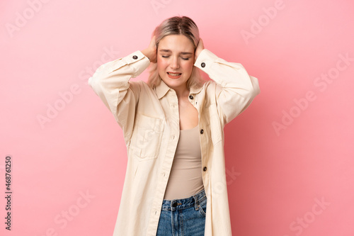 Young caucasian woman isolated on pink background frustrated and covering ears © luismolinero
