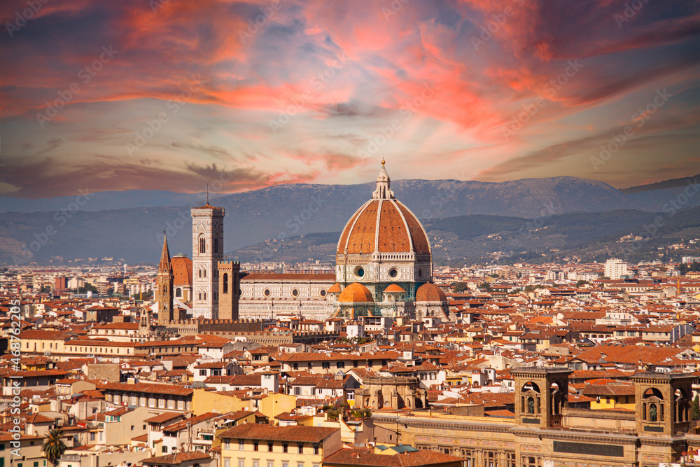 Santa Maria del Fiore cathedral in Florence, Italy. Aerial panoramic view with dome by Brunelleschi, and bell tower dominating the skyline in Tuscany, Italy. Spectacular red sunset sky background.