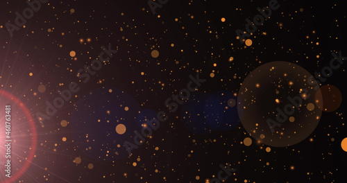 Image of sunrays and golden dots falling on black background