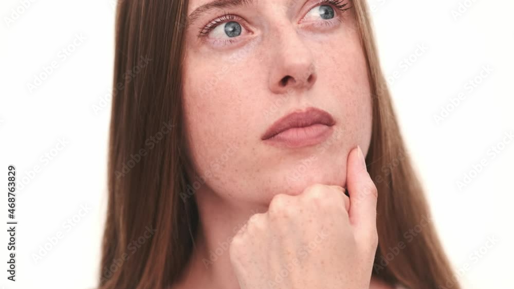 Close-up view of pensive woman thinking in white studio Close-up view of pensive woman thinking in white studio