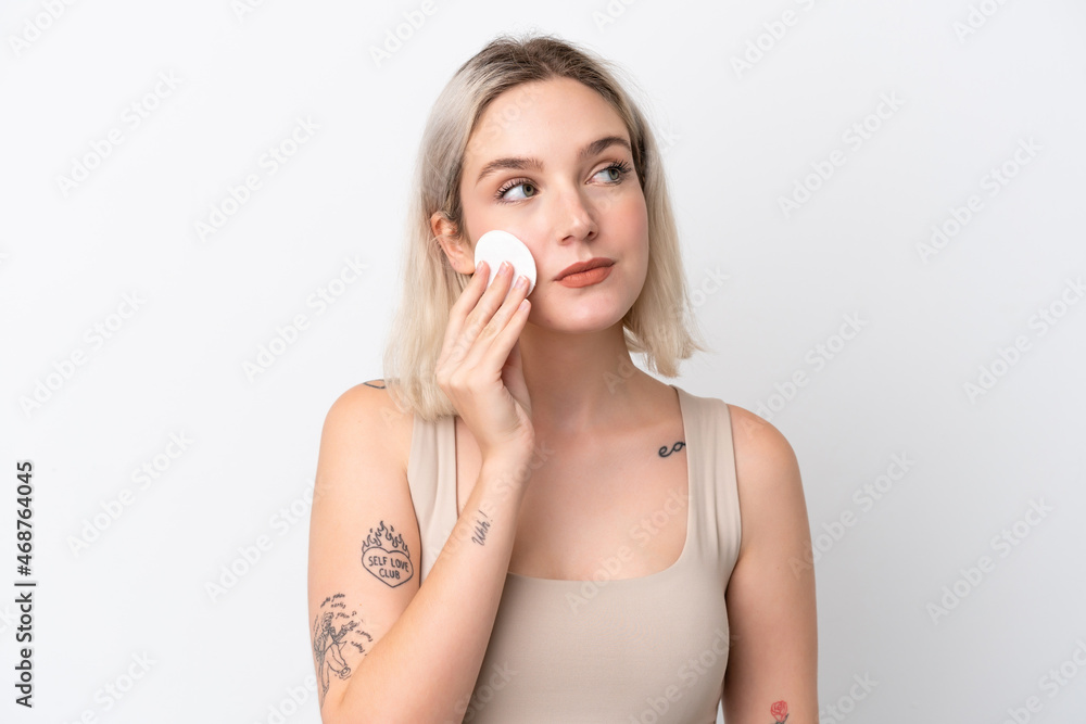 Young caucasian woman isolated on white background with cotton pad for removing makeup from her face Young caucasian woman isolated on white background with cotton pad for removing makeup from her face