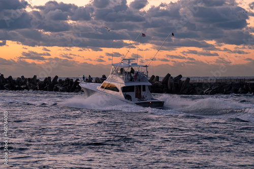 Motor boats heading out of Manasquan inlet at sunrise to go fishing