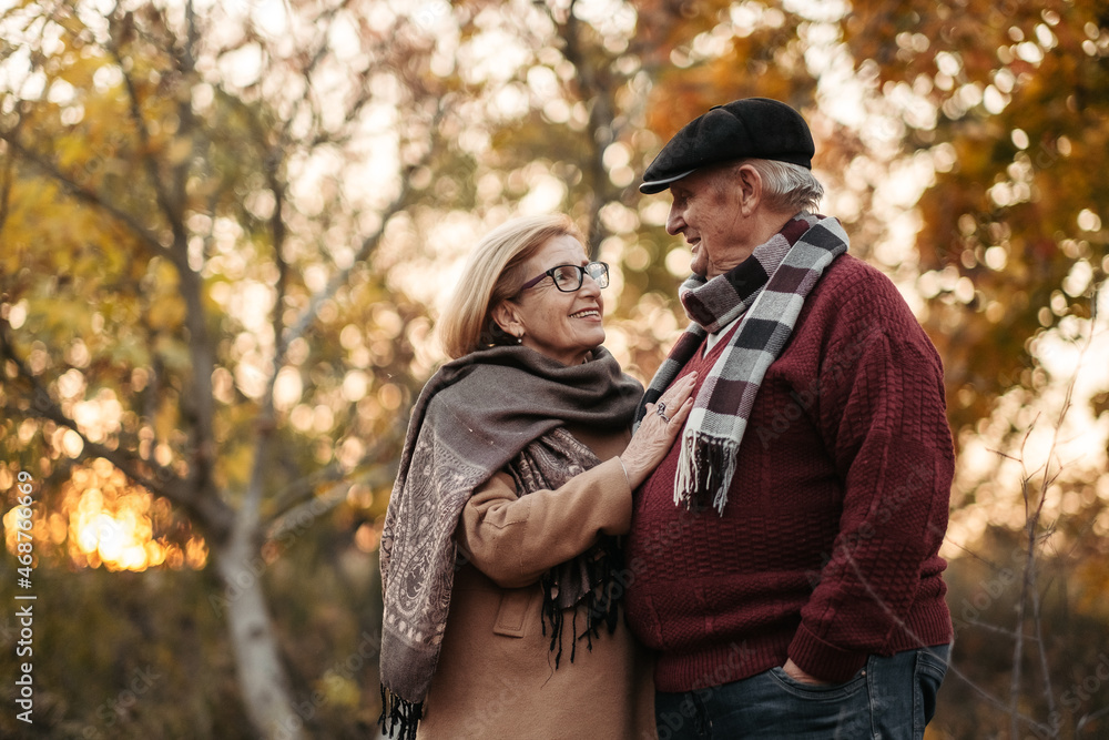 Elderly man lovingly looks at his elegant pensioner, hugs and enjoys her beauty, senior married couple dancing in autumn park, celebrating anniversary, affection Elderly man lovingly looks at his elegant pensioner, hugs and enjoys her beauty, senior married couple dancing in autumn park, celebrating anniversary, affection