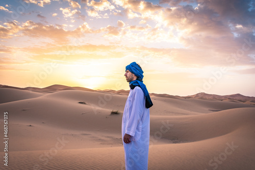 Berber man wearing traditional tuareg clothes in the Sahara Desert at dawn, Merzouga, Morocco photo
