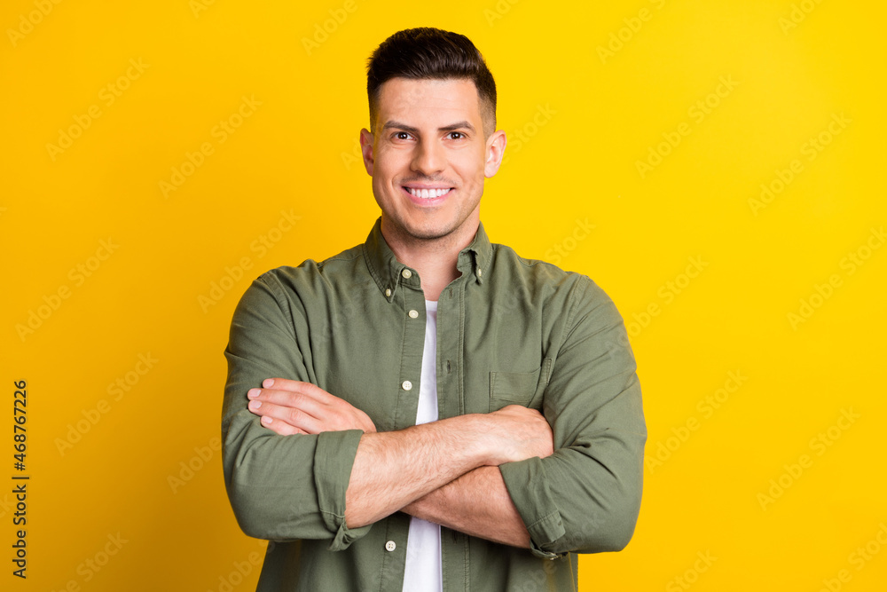 Fototapeta premium Photo portrait man smiling crossed hands isolated vivid yellow color background