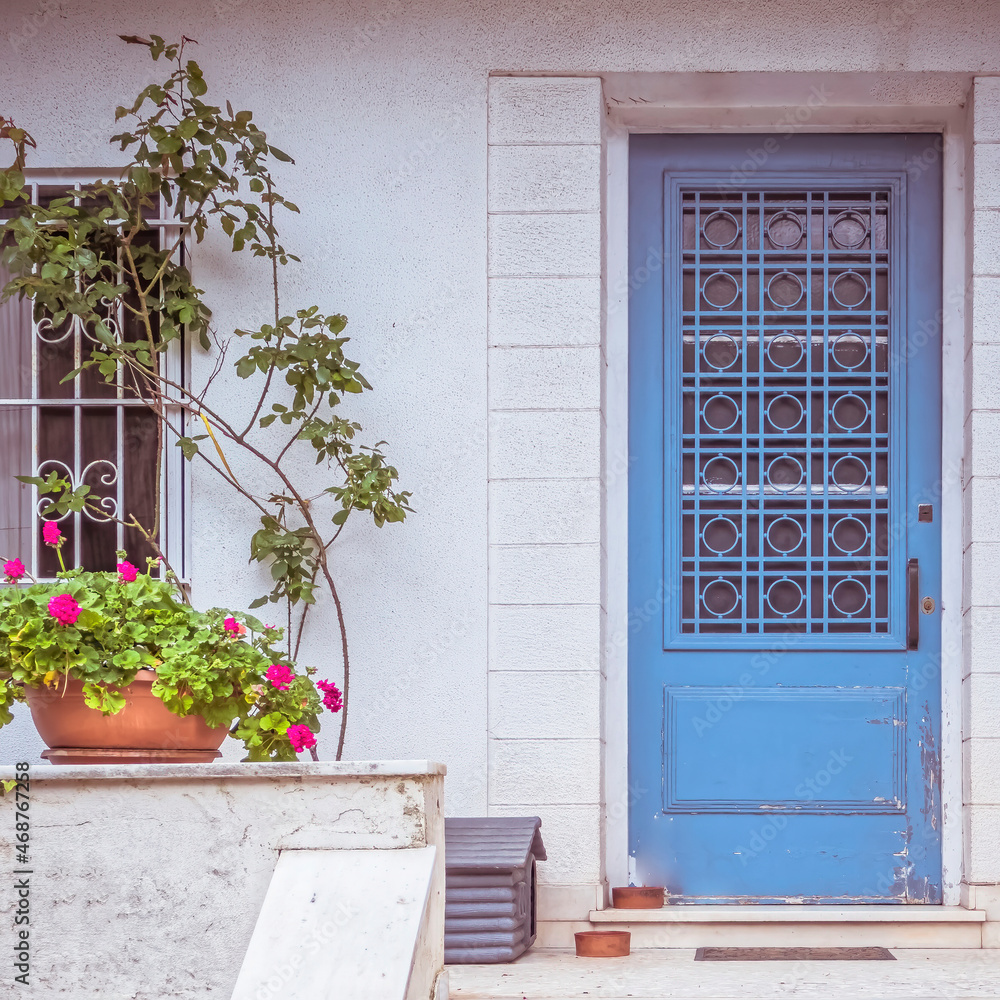 traditional house entrance light blue door and flowerpot, Athens Greece
