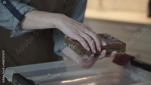 A woman holding a frame for making paper sheets from recycled paper. Selective focus. Household hobby, paper recycling. The concept of zero waste, recycling, ecology