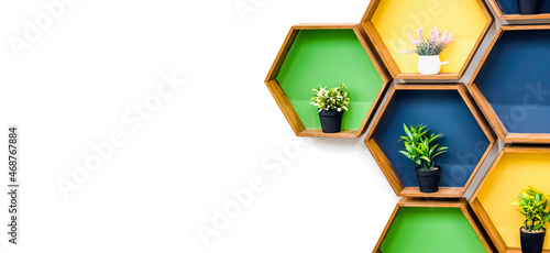 A banner with a white background for a furniture company with unusual colored shelves and pots with artificial flowers. Copy space. Indoors. Square shelves. Succulents as decoration.