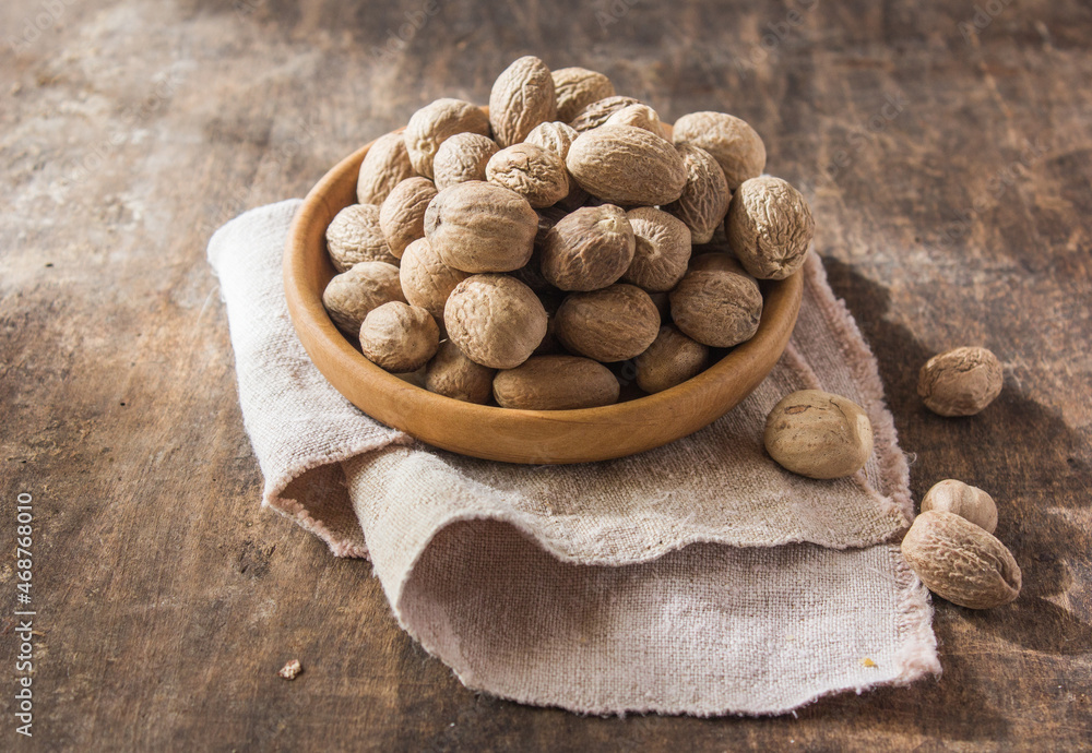 Nutmeg .Whole and ground nutmeg in a wooden bowl Nutmeg .Whole and ground nutmeg in a wooden bowl