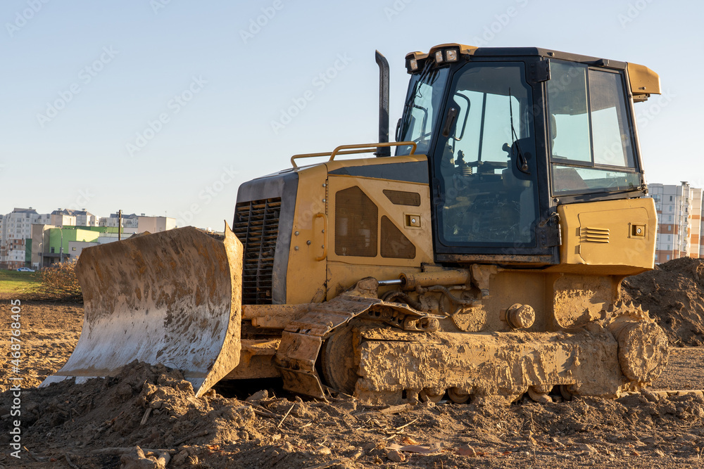 yellow bulldozer levels the ground in front of a hospital development for covid treatment yellow bulldozer levels the ground in front of a hospital development for covid treatment