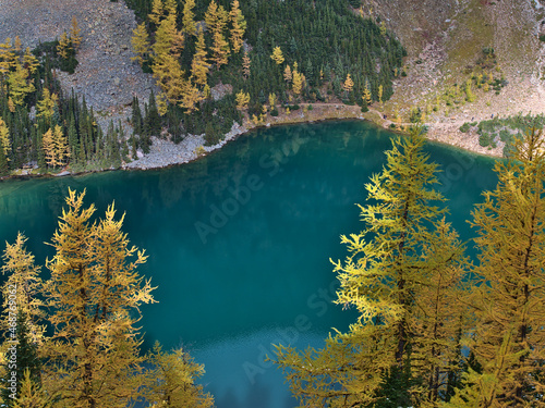 Fototapeta Naklejka Na Ścianę i Meble -  Aerial view of Lake Agnes in autumn with yellow larch trees and green shimmering water in a valley near Lake Louise, Banff National Park, Canada.