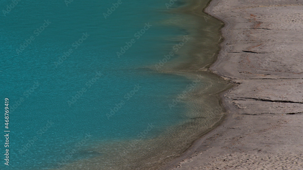 High angle view of the sandy shore of Lake Louise with characteristic turquoise colored water in Banff National Park, Alberta, Canada in the Rockies. High angle view of the sandy shore of Lake Louise with characteristic turquoise colored water in Banff National Park, Alberta, Canada in the Rockies.