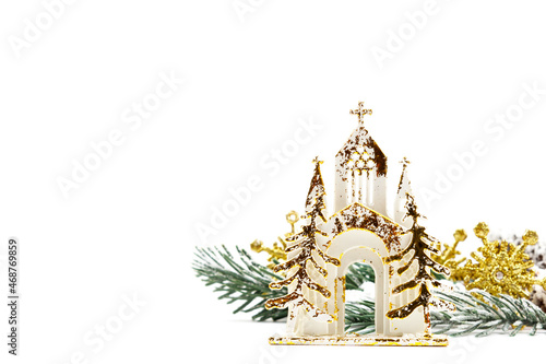 Christmas card on an isolated white background with a golden temple and a spruce branch sprinkled with snow. Happy new year 2022 greetings. Copy space. Flat lay