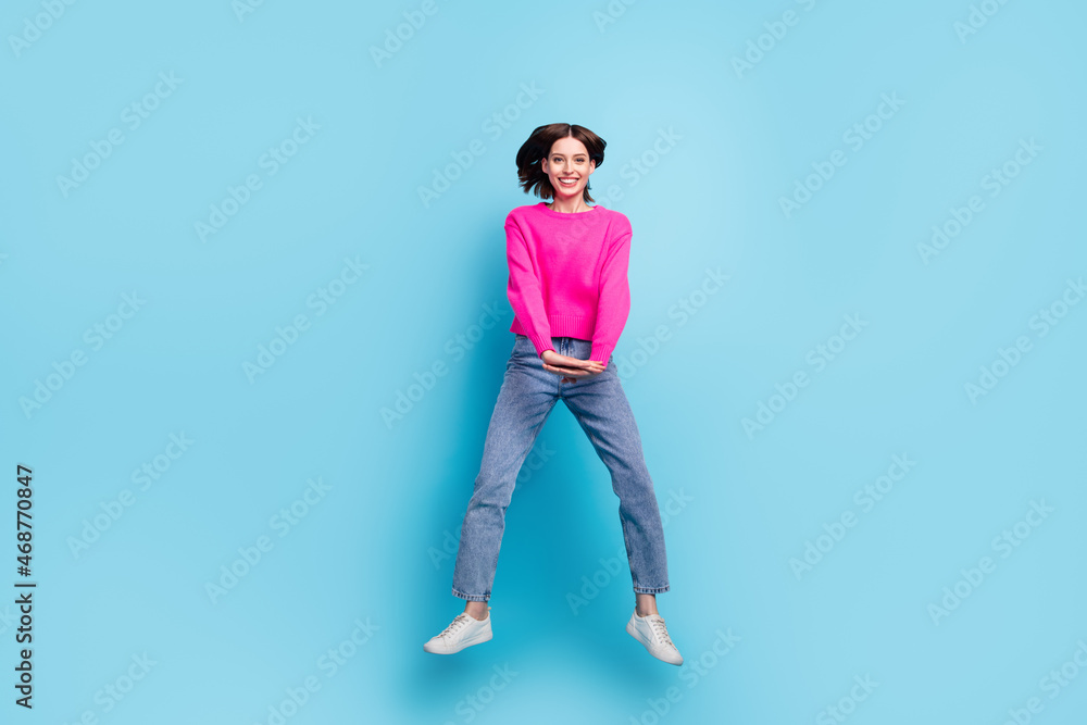 Full length body size view of attractive cheerful girl jumping having fun isolated over bright blue color background Full length body size view of attractive cheerful girl jumping having fun isolated over bright blue color background