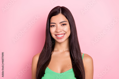 Photo of cute adorable young woman dressed green singlet smiling isolated pink color background