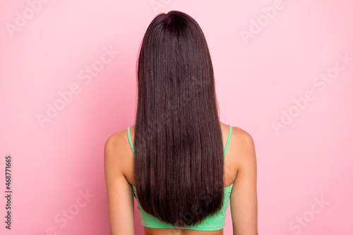 Photo of shiny beautiful young woman hair dressed green singlet standing back isolated pink color background