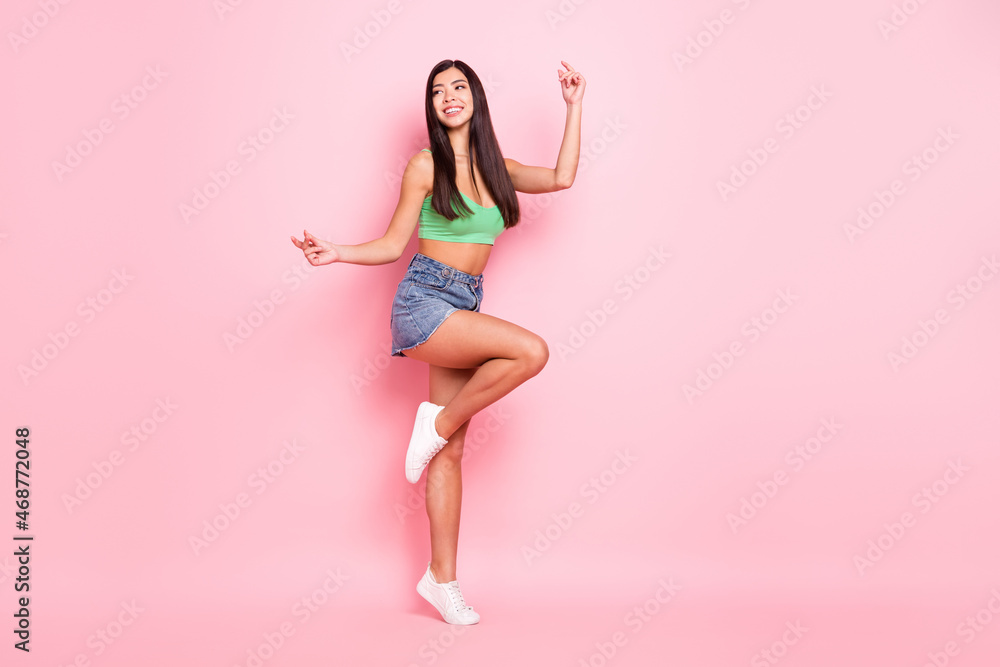 Photo of shiny funky young woman hair dressed green singlet smiling dancing isolated pink color background Photo of shiny funky young woman hair dressed green singlet smiling dancing isolated pink color background