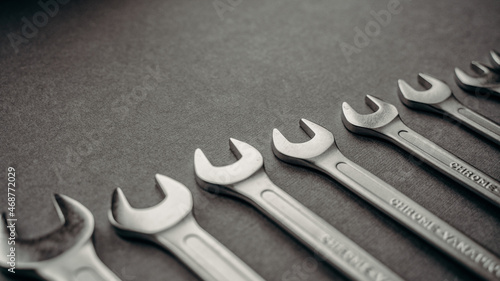 a set of wrenches of different sizes on a gray industrial background