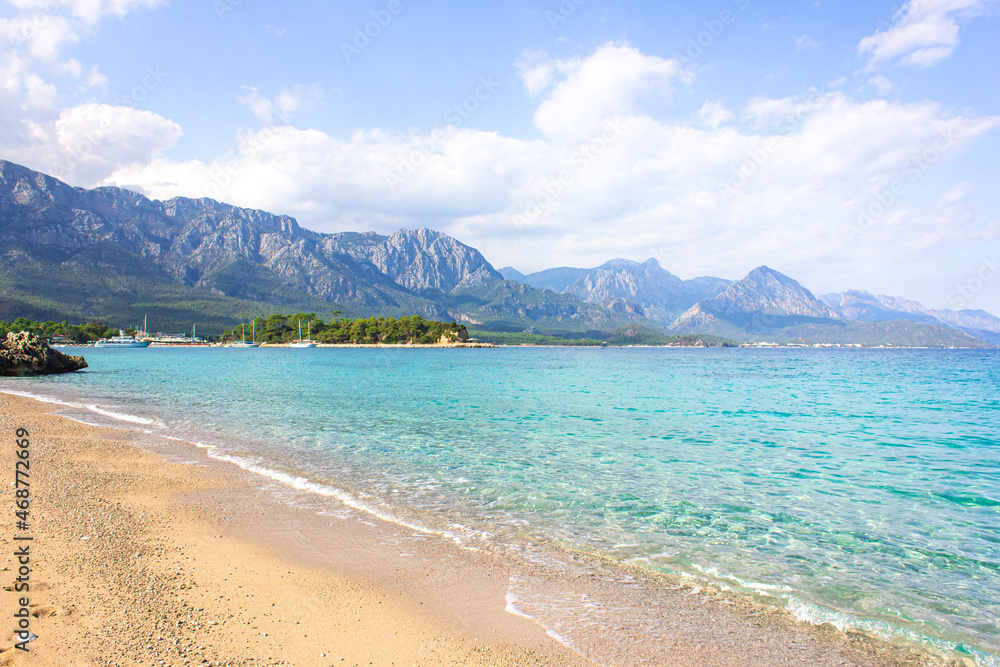 Seascape: clear blue sky, turquoise sea and mountains on the shore. Coastline of Kemer, Turkey.