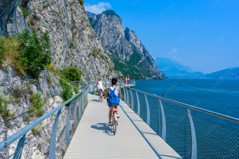 "Ciclopista del Garda" - Bicycle road and foot path over Garda lake with beautiful landscape scenery at Limone Sul Garda - travel destination in Brescia, Italy - obrazy, fototapety, plakaty 