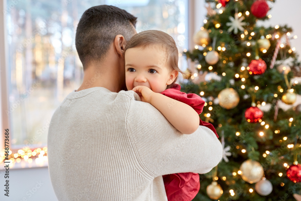 winter holidays and family concept - happy middle-aged father and baby daughter over christmas tree at home winter holidays and family concept - happy middle-aged father and baby daughter over christmas tree at home