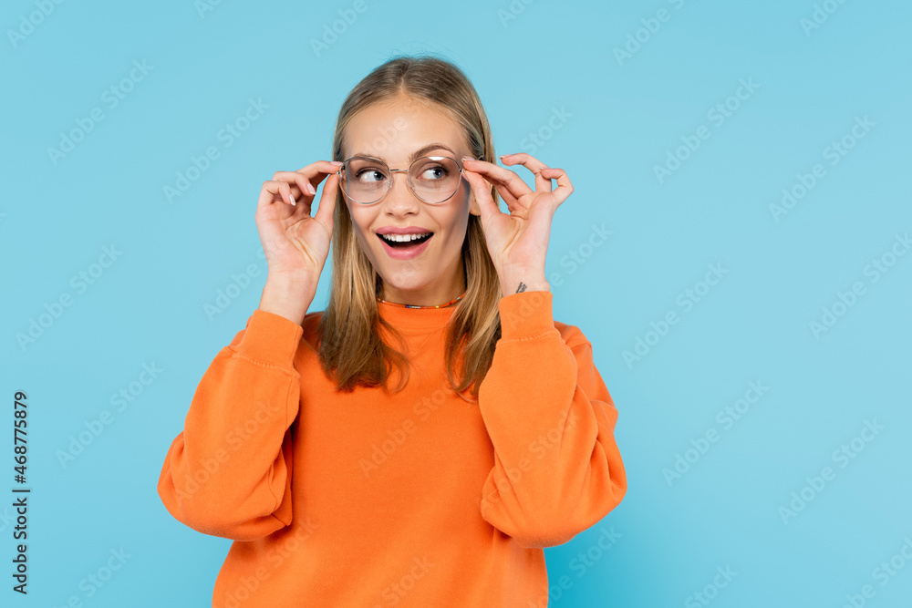 Pretty brunette woman holding eyeglasses isolated on blue Pretty brunette woman holding eyeglasses isolated on blue