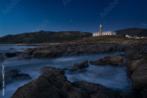 Lighthouse at night with starry sky. Canota, Galicia, Spain