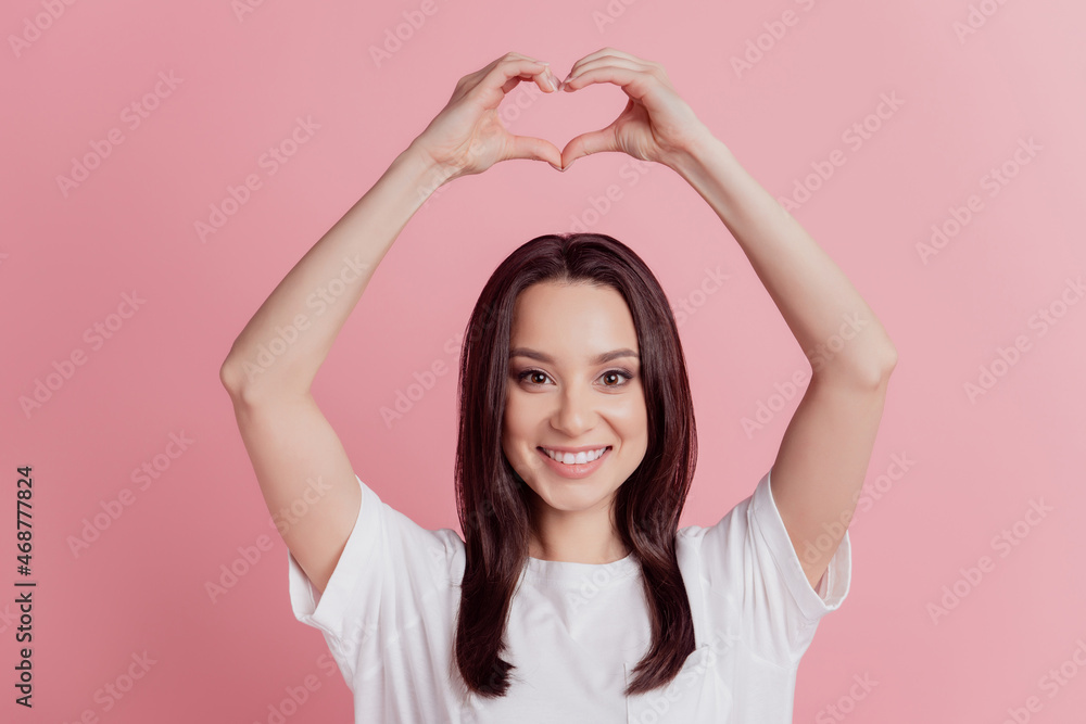 Photo of young lovely lady show fingers heart symbol love romantic valentine day isolated over pink color background Photo of young lovely lady show fingers heart symbol love romantic valentine day isolated over pink color background