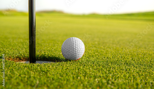 golfed ball on golf course of green grass
