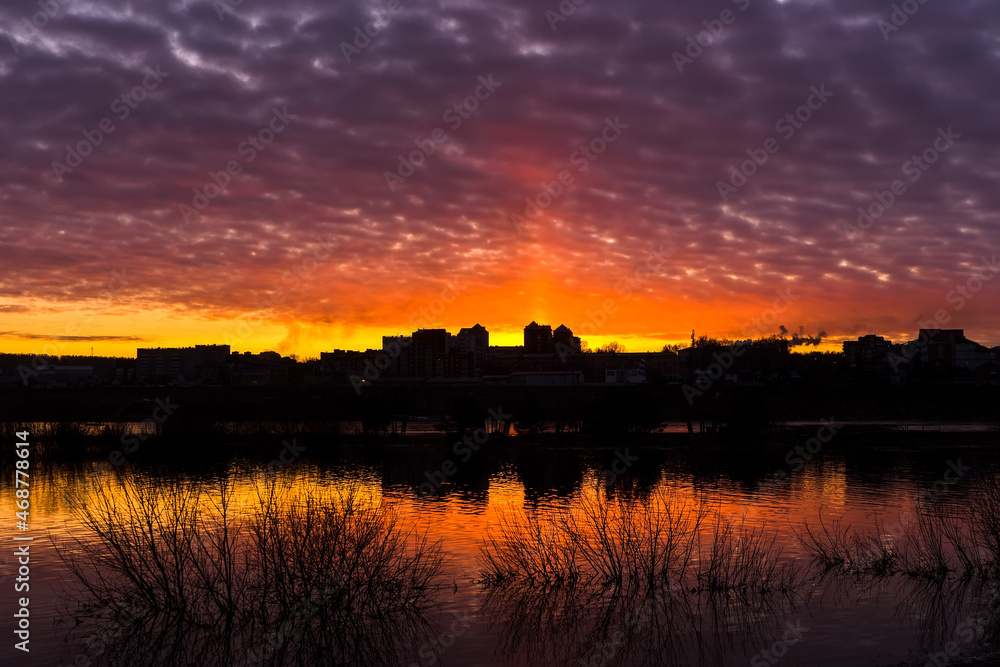 Sunset with lilac clouds, city and grass silhouettes. Sunset with lilac clouds, city and grass silhouettes.