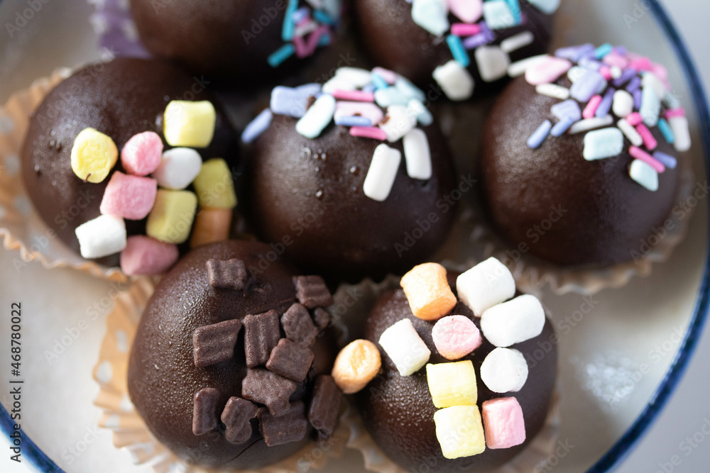Chocolate balls sprinkled with colored sugar, cute cakes.