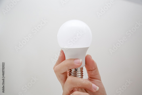 Lampada led de energia branca na mão de uma pessoa segurando.